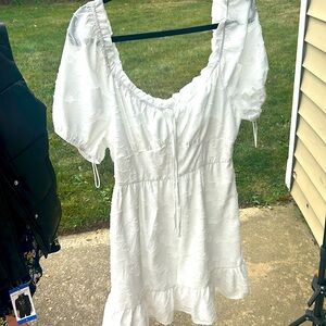 White cinched waist dress, embossed floral print with ruffled hem and neckline